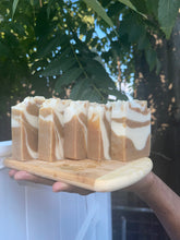 Load image into Gallery viewer, Noureture By Nature’s Ginger Turmeric Honey Handmade Soap. Handmade Vegan Soap. Organic Ingredients Soap. All-Natural Handmade Soap. Cruelty Free Ingredients Soap. Small Business Soap. Black Women in Business Soap. Handmade Soap on a wooden board, held by male on a beautiful sunny day. Nigerian Shea Butter Handmade Soap.
